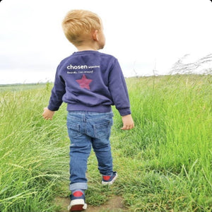 Chosen-sweatshirt-boy-walking-through-grass