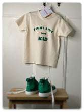 Load image into Gallery viewer, Fight-like-this-kid-childrens-adoption-tshirt-cream-with-green-slogan-one-of-the-items-from-the-adoption-clothing-range-from-notafictionalmum
