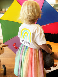 Child-wearing-forever-white-tshirt-rainbow-logo-with-tuttu-umbrella