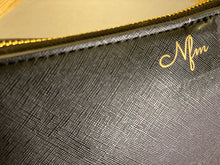 Load image into Gallery viewer, close-up-nfm-logo-in-gold-on-black-leather-bag
