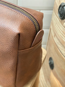 brown-leather-effect-washbag-close-up-on-zip