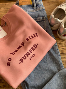 folded- no-bump-still-pumped-club-sweatshirt-pink-folded-on-top-of-jeans